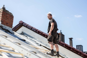 Dachdecker steht sicher auf einem Dach bei der Arbeit