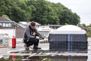 Dachdecker arbeitet mit Gasbrenner an Lichtkuppel